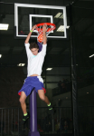 Man Two Hand Reverse Slam Dunking at Trampoline Basketball Park
